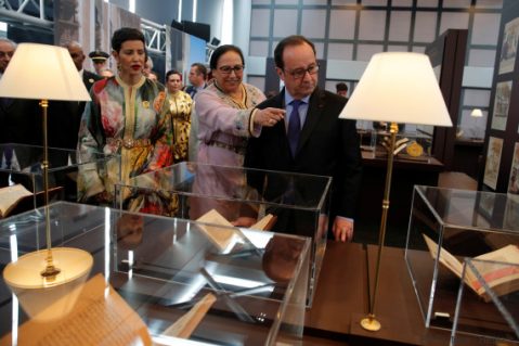 Bahija Simou (C), curator of the exibition "Splendeurs de l'Ecriture au Maroc", shows a books to French President Francois Hollande while Morocco's Princess Lalla Meryem (L) looks on at the Arabic World Institute (IMA) in Paris, France, March 22, 2017. REUTERS/Christophe Ena/Pool